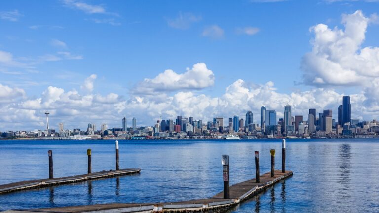 Wooden pier over a sea with the city of Seattle, USA under the beautiful clouds in the background